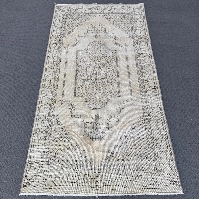 Elegante alfombra oriental beige 100 x 190 cm con detalles en negro