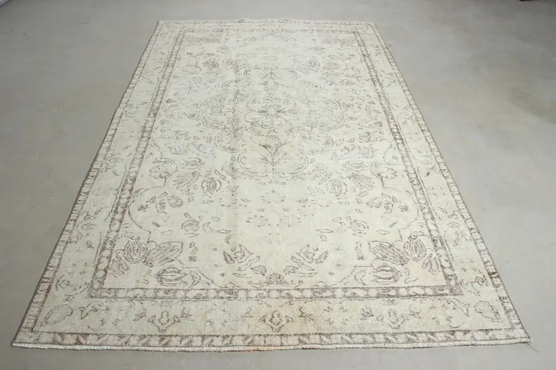 Elegante alfombra beige con diseño de bordes de 5,5 x 9 pies