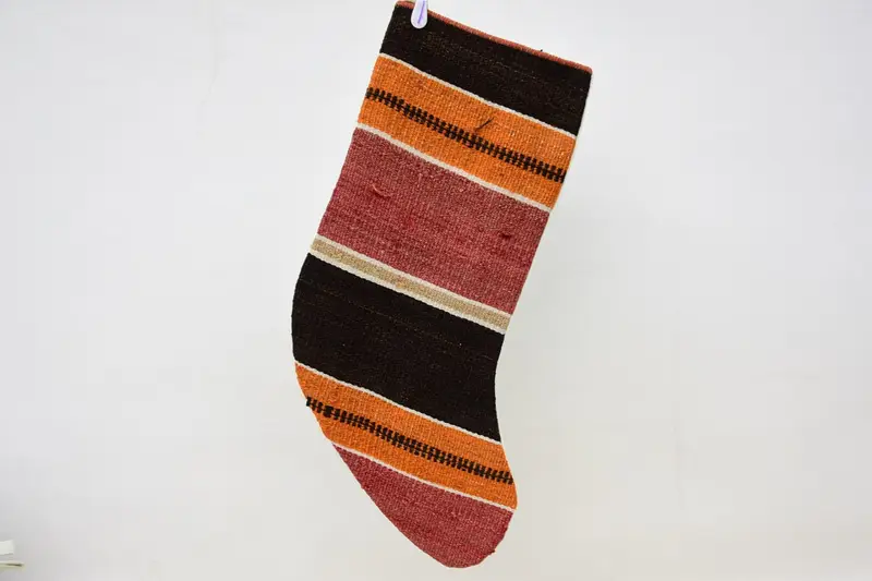 お祝いの赤とオレンジのクリスマスオーナメントストッキング、居心地の良いホリデーデコレーション