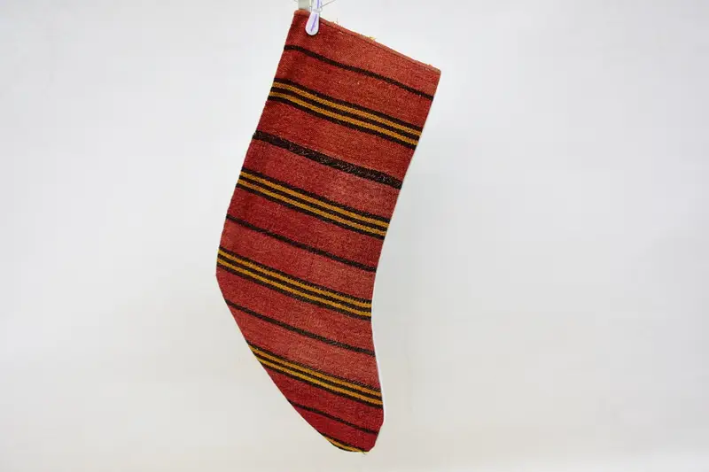 お祝いの赤とオレンジのクリスマスオーナメントストッキング、居心地の良いホリデーチャーム